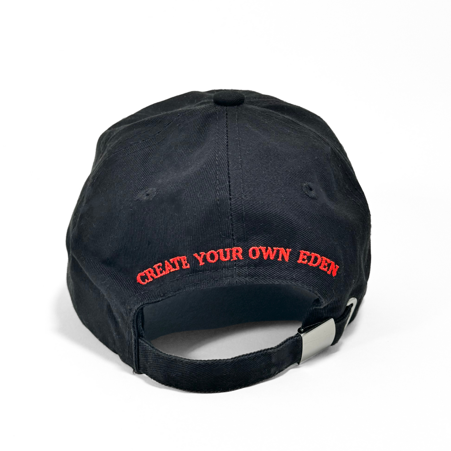 The back of the Socaboy Noir Cap is photographed against a white backdrop. The back of the hat features red embroidery of the affirmation 'create your own eden'
